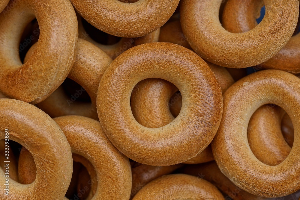 brown background of small round bagels in a heap brown background of small round bagels in a heap
