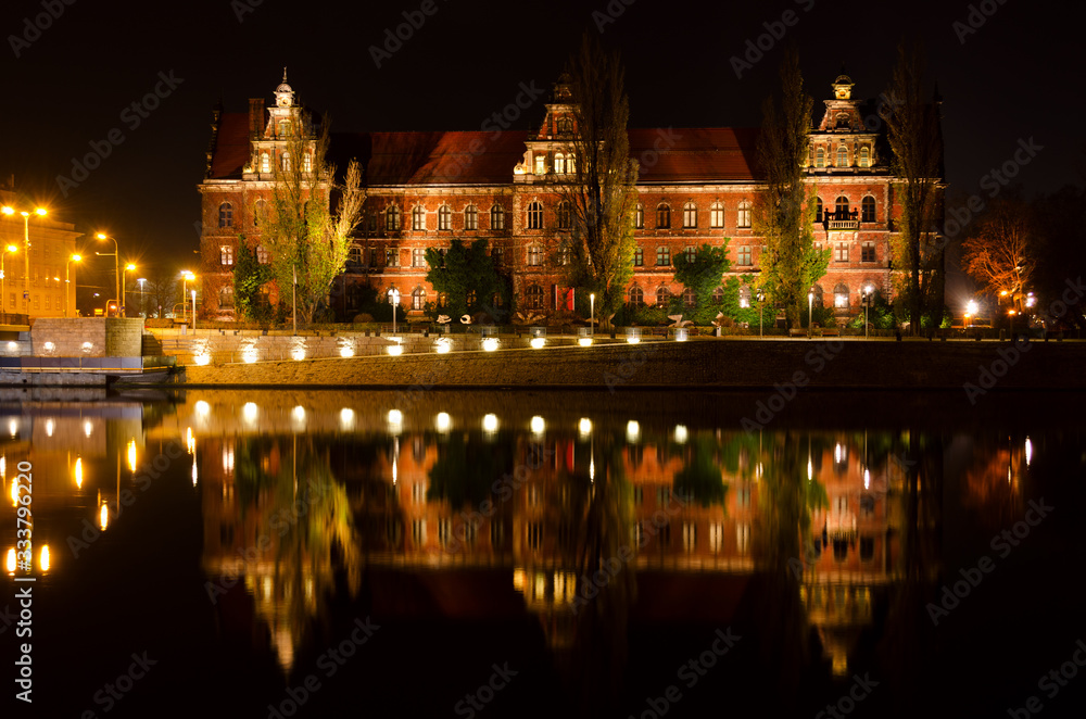 National Museum, Muzeum Narodowe, of Wroclaw shoted in the evening and its reflection in Odra river