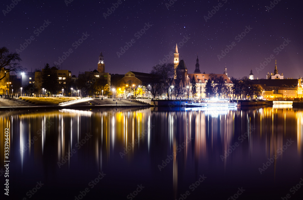 Panoramic view of Night Wroclaw City, Odra river and reflections of historical buildings in it.