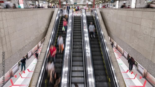 4K Time-lapse of Asian people walking and using escalator at MRT subway underground station in Singapore. Public transportation, Asia everyday city life, or commuter urban lifestyle concept. Tilt up