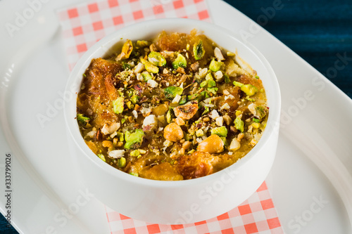 Turkish dessert kunefe, kunafa, kadayif with pistachio powder and cheese, served hot, very sweet. Turkish traditional dessert.