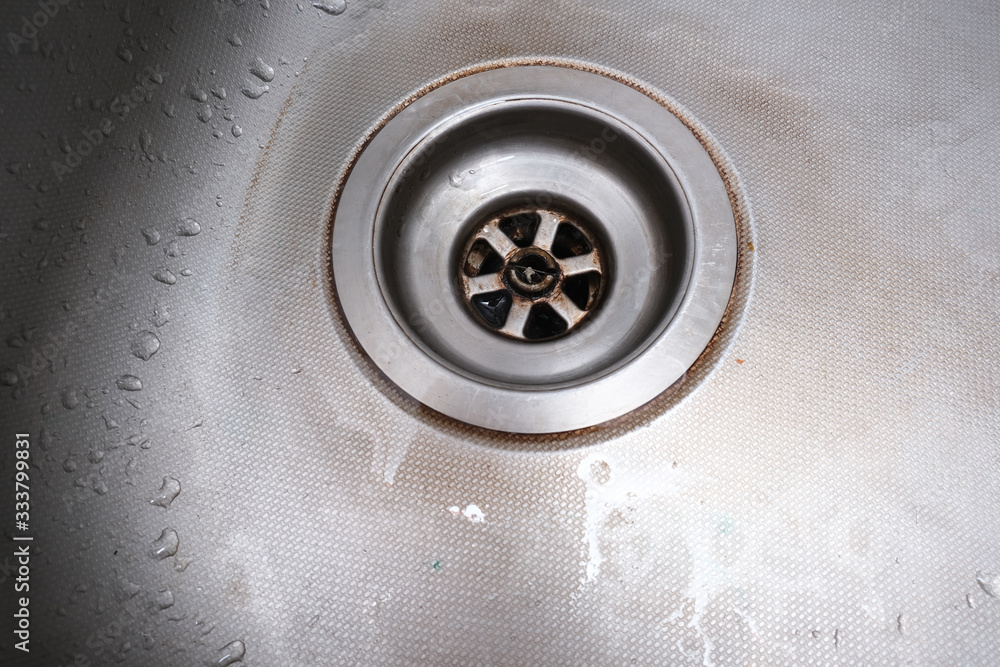 Old rusty calcified drain hole in the kitchen sink with limescale and