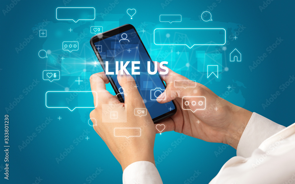 Female hand typing on smartphone with LIKE US inscription, social media concept Female hand typing on smartphone with LIKE US inscription, social media concept