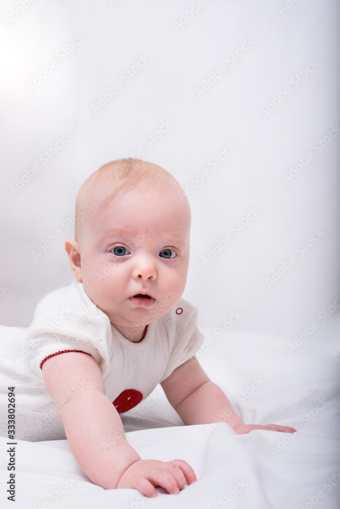 Portrait of cute little baby lying down on bed. 3 months baby Vertical frame
