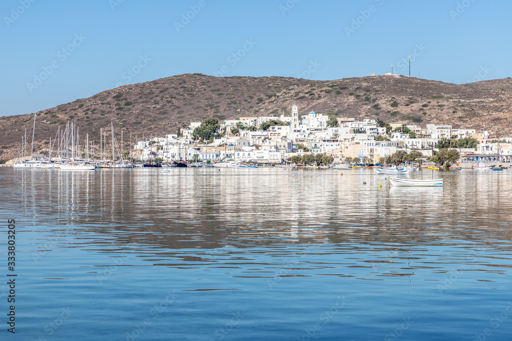 Adamas village with boats and mountain reflecting in Milos bay Adamas village with boats and mountain reflecting in Milos bay