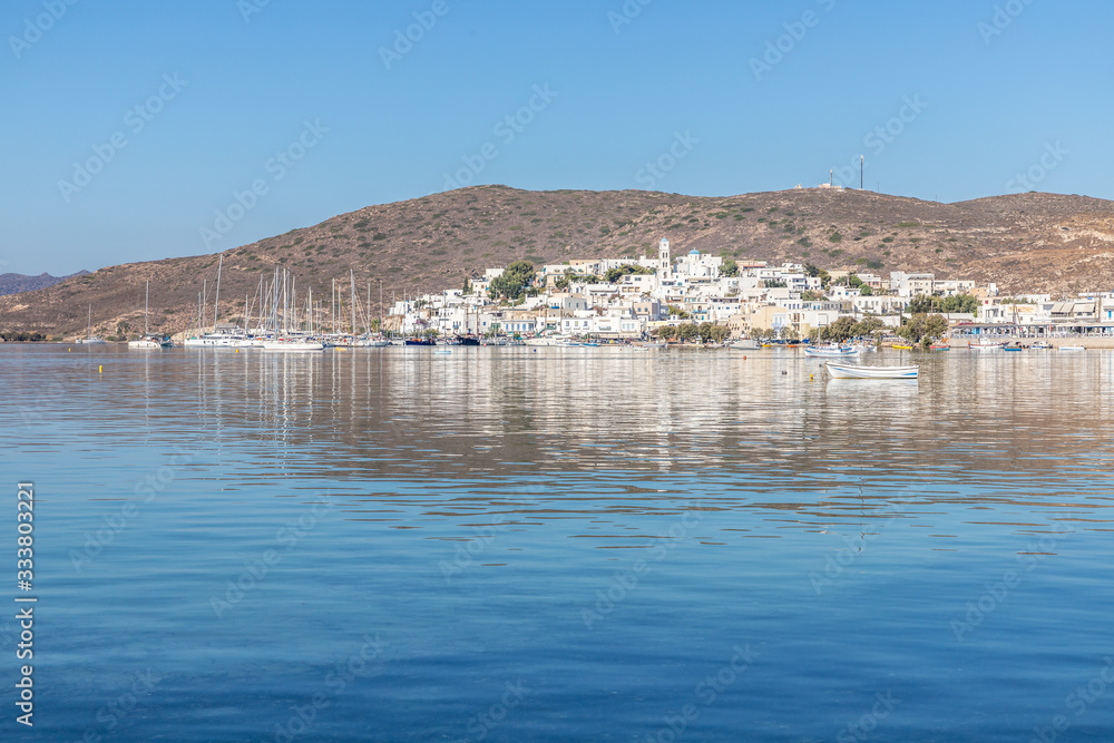 Adamas village with boats and mountain reflecting in Milos bay