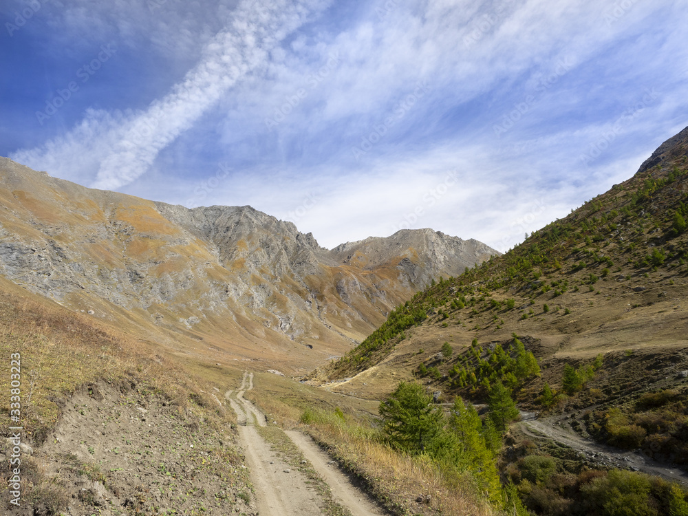 dirt road leads to the peaks of the mountains dirt road leads to the peaks of the mountains