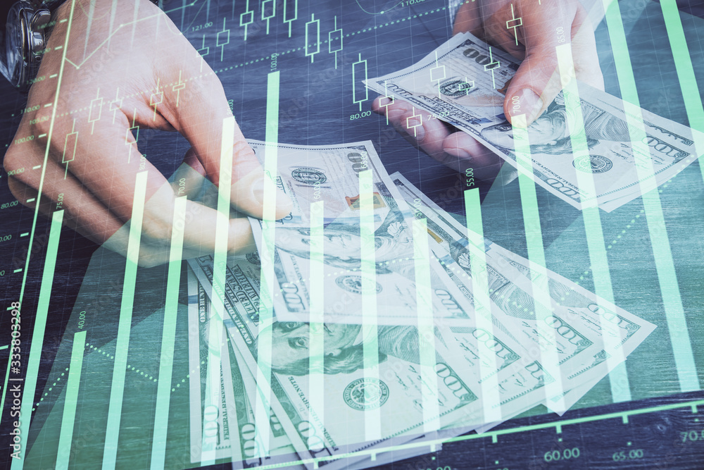 Multi exposure of financial graph drawing hologram and USA dollars bills and man hands. Analysis concept. Multi exposure of financial graph drawing hologram and USA dollars bills and man hands. Analysis concept.