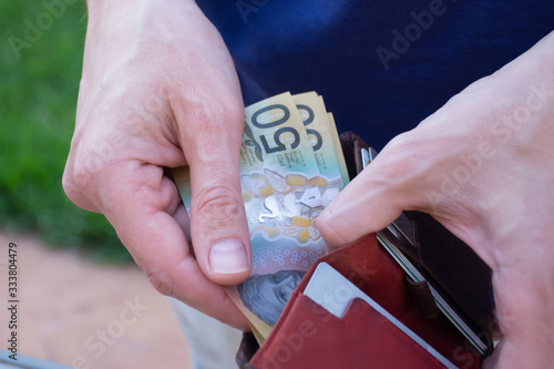 Hands holding wallet with australian dollars and counting money - coronavirus finance struggle concept photo