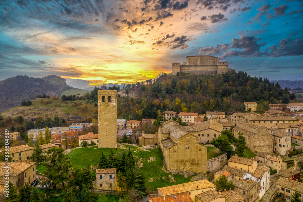 Aerial view of San Leo town and fortress used once as a prison on a rocky outcrop near the Adriatic sea resort Rimini and San Marino with Roman church