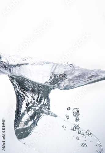 The water bottle falls into the water until the water is beautifully dispersed. Freshness on a white background.