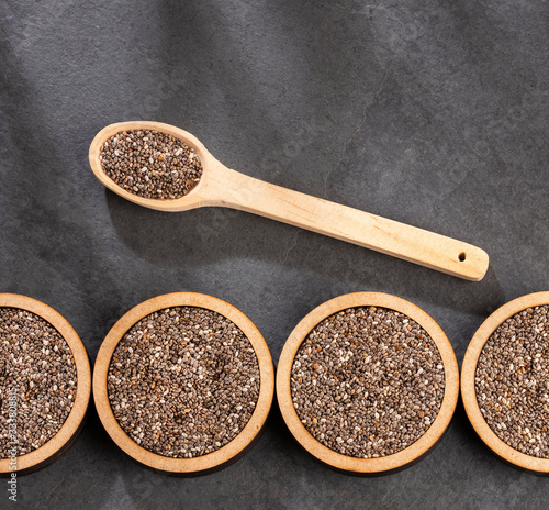 Organic chia seeds in spoon and wooden bowls - Salvia hispanica
