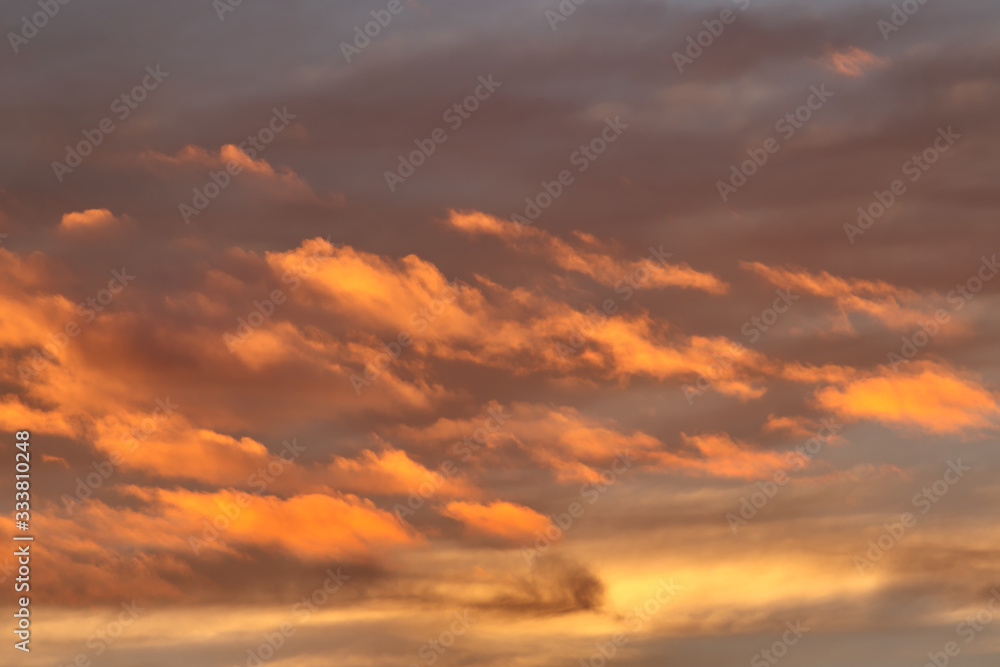 band of clouds illuminated by twilight, floating gently under the cloudy blue sky