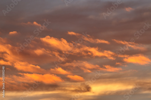band of clouds illuminated by twilight, floating gently under the cloudy blue sky © conpuli