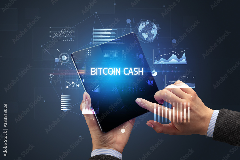 Businessman holding a foldable smartphone with BITCOIN CASH inscription, successful business concept Businessman holding a foldable smartphone with BITCOIN CASH inscription, successful business concept