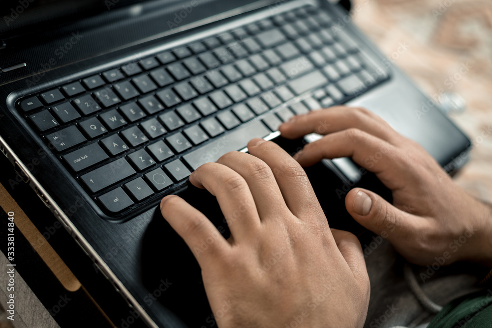 Remote work during quarantine. A man works at a laptop, closeup keyboard. Horizontal frame Remote work during quarantine. A man works at a laptop, closeup keyboard. Horizontal frame
