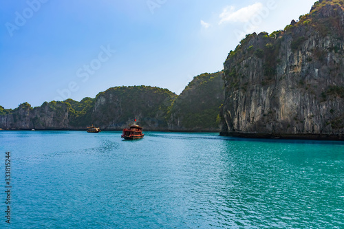 Halong bay islands. Tourist attraction, spectacular limestone grottos natural cave formations. Karst landforms in the sea, the world natural heritage. Beautiful azure water of the lagoon. Two boats 