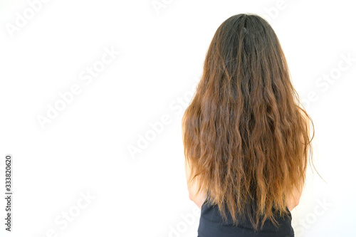 Back view of woman with her damaged split ended hair. Hair damage is risk for further damage and breakage. It may also look dull or frizzy and be difficult to manage.