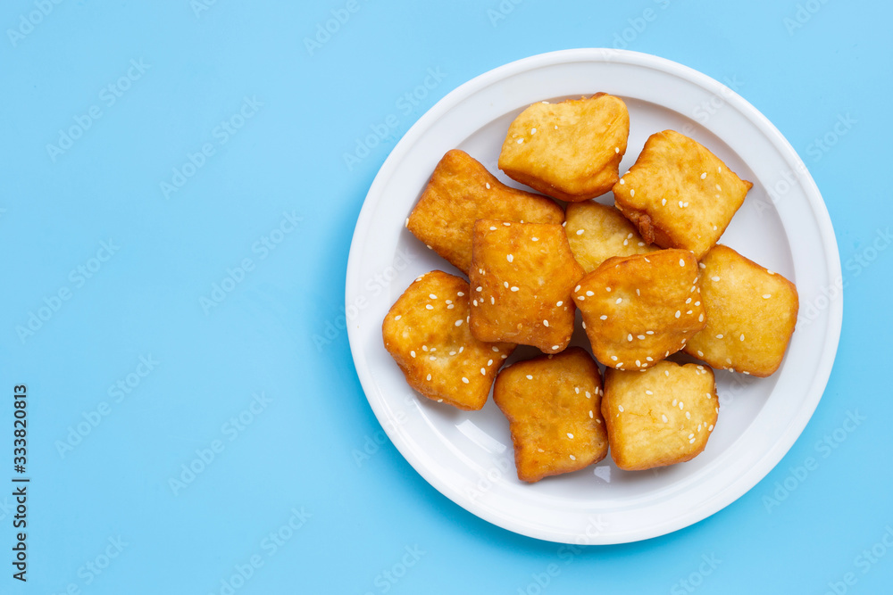 Chinese deep fried dough sticks with white sesame seeds on blue background. Chinese deep fried dough sticks with white sesame seeds on blue background.