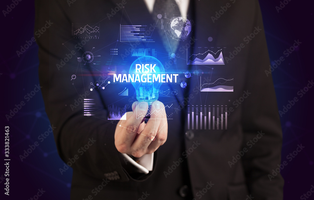 Fototapeta premium Businessman holding lightbulb with RISK MANAGEMENT inscription, Business idea concept