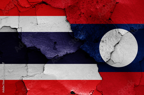 flags of Thailand and Laos painted on cracked wall