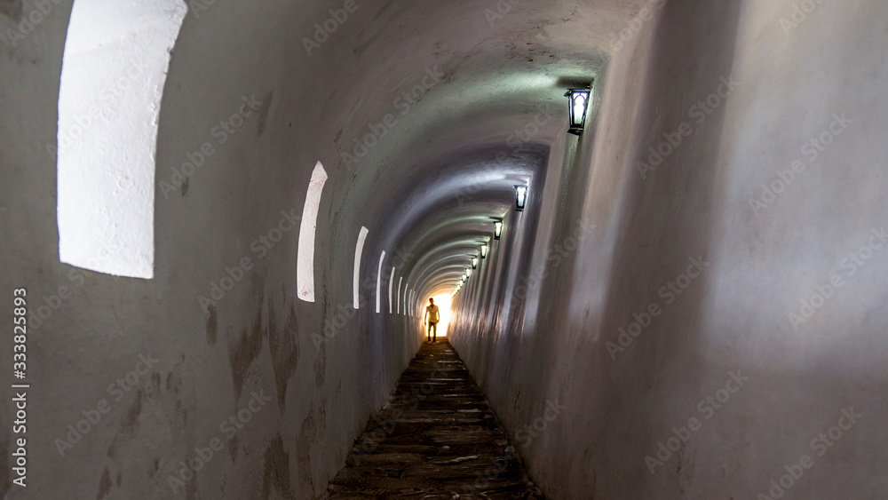 Obraz premium Unrecognizable man`s silhouette walking through a tunnel.
