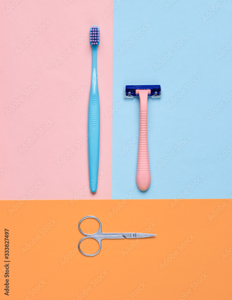 Minimalistic personal care, beauty concept. Plastic razor, toothbrush, nail scissors on colored background. Top view Minimalistic personal care, beauty concept. Plastic razor, toothbrush, nail scissors on colored background. Top view