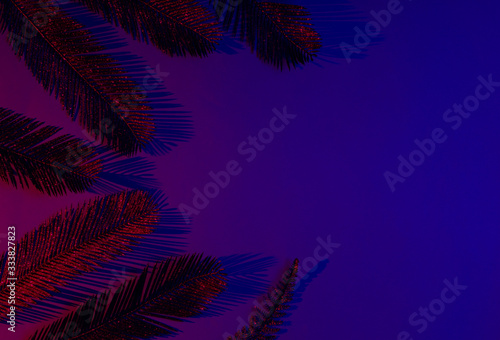 Creative pop art tropical concept. Golden palm leaves on blue-red neon gradient background. Copy space. Top view © splitov27