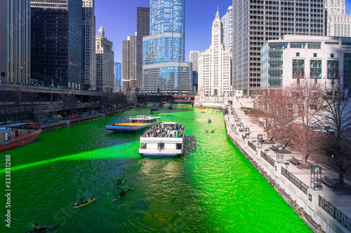 Obraz na płótnie Chicago building and cityscape on Saint Patrick's day around Chicago river walk with green color dyeing river in Chicago Downtown, illinois, USA, crowned irish and american people are celebrating. w salonie