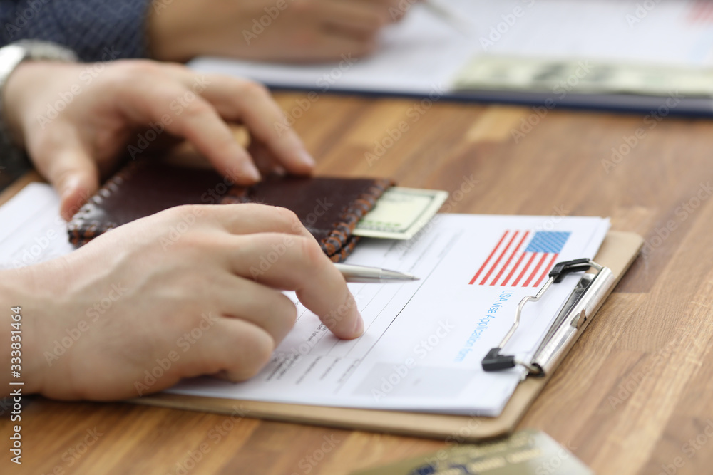 Male hands in suit lie on application for usa visa. Registration in the system embassies. Priority clearance. Checking petition and paying consular fee. Increase chances getting visa Male hands in suit lie on application for usa visa. Registration in the system embassies. Priority clearance. Checking petition and paying consular fee. Increase chances getting visa