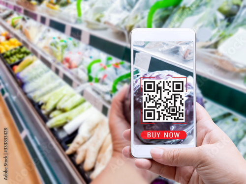 Online order grocery shopping on touch screen concept. Woman hand holding smart phone with checks the QR code or e-wallet on label for ingredient and payment. Business and technology for lifestyle.