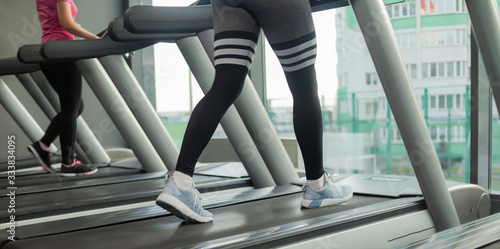 Healthy lifestyle concept. Female legs run on a treadmill in the gym
