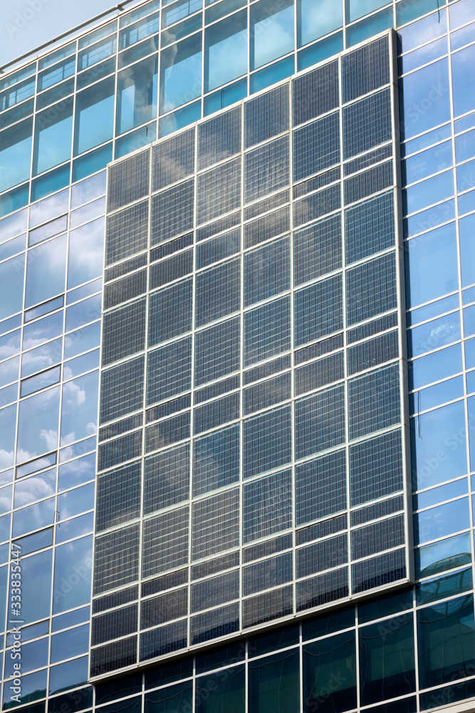 Obraz premium Solar cell panel on glass wall of building