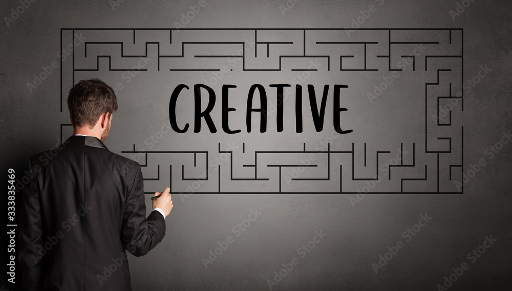 businessman drawing maze with CREATIVE inscription, business education concept businessman drawing maze with CREATIVE inscription, business education concept