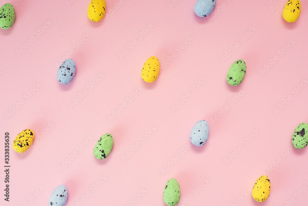 Multi-colored quail eggs on a pink background. Yellow, blue and green little easter eggs. Seamless pattern Multi-colored quail eggs on a pink background. Yellow, blue and green little easter eggs. Seamless pattern