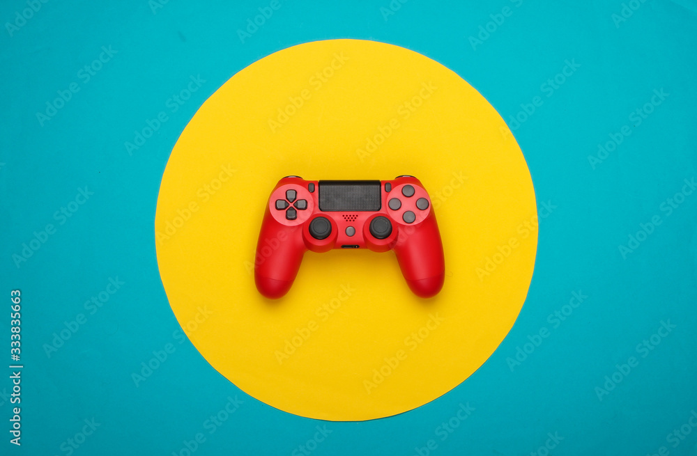 Red gamepad on blue  background with yellow circle. Gaming, leisure and entertainment concept. Top view