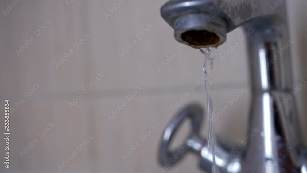 Washbasin with dripping tap iin sunny bathroom with window Washbasin with dripping tap iin sunny bathroom with window