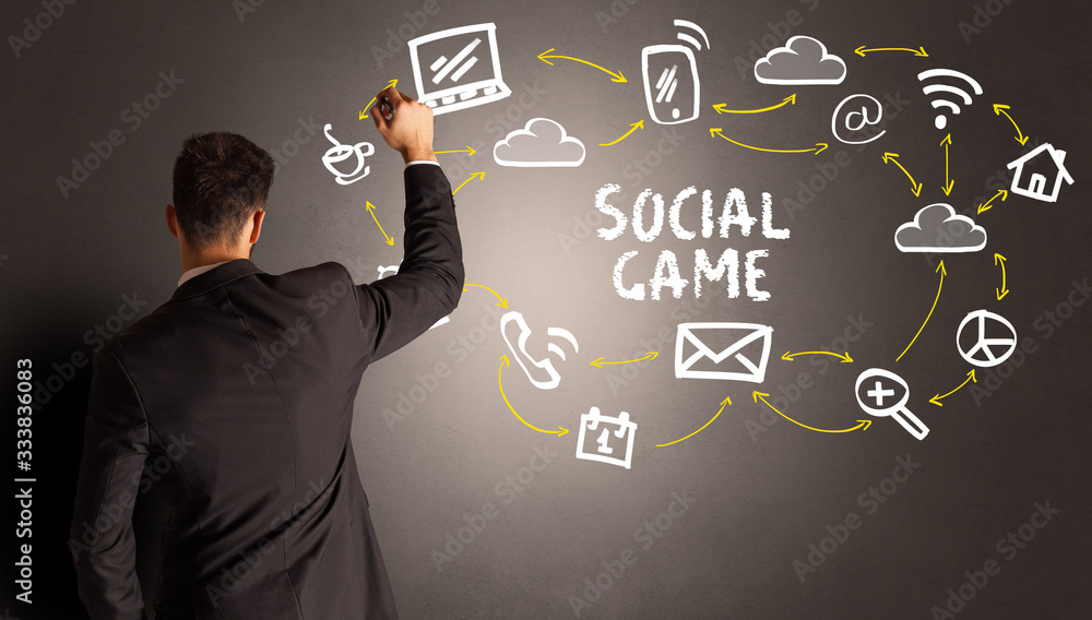 businessman drawing social media icons with SOCIAL GAME inscription, new media concept businessman drawing social media icons with SOCIAL GAME inscription, new media concept