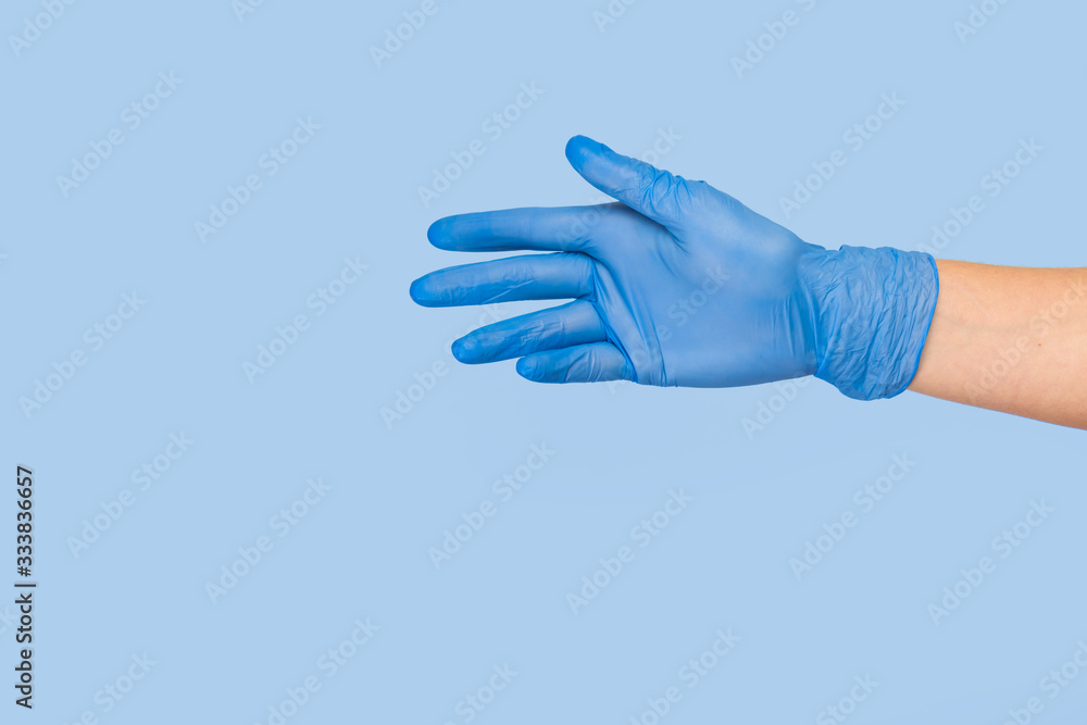 Doctor hand glove shows number five front on blue background. Doctor hand glove shows number five front on blue background.