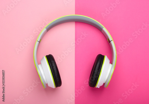 Stylish wireless stereo headphones on pink pastel background. Music lover. Gadgets. Top view.