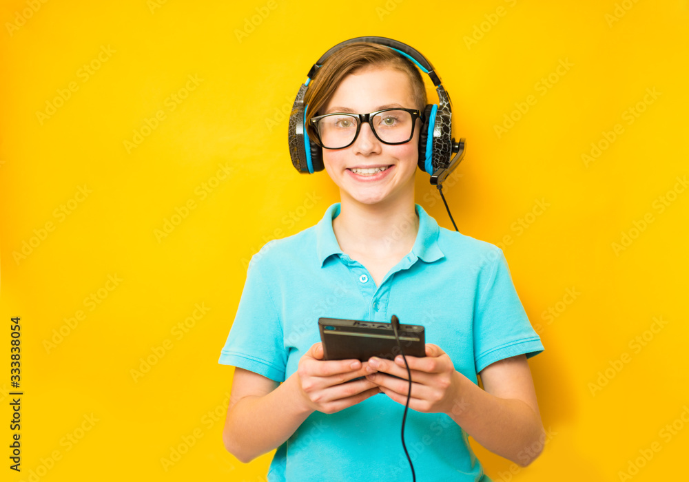 Smiling boy does his homework in headphones and with a tablet. Distance learning in quarantine Smiling boy does his homework in headphones and with a tablet. Distance learning in quarantine