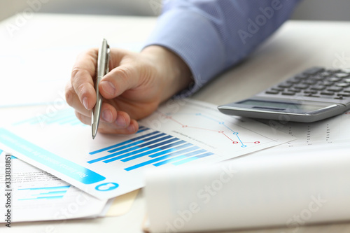 Accountant Manager Controlling Expense Income. Man Hold Pen at Work Table, Check Financial Data with Chart. Male Booker Planning Annual Economy Report Using Calculator. Salary Growth Calculation