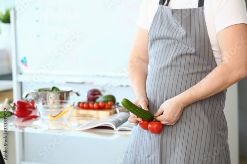Cheerful Chef Showing Sexy Food Vegetable Erection. Man in Apron Joking at Culinary Blog. Comic Male with Tomato and Cucumber at Kitchen. Fresh Penis Potency Humor. Horizontal Photography