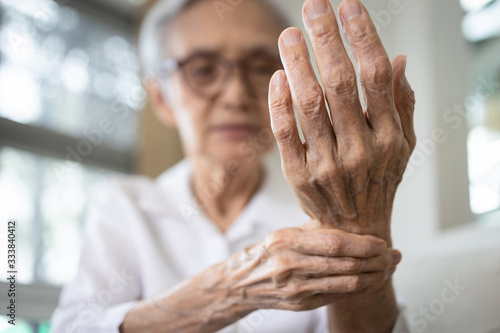 Elderly female patient suffer from numbing pain in hand,numbness fingertip,arthritis inflammation,beriberi or peripheral neuropathies,senior woman massage her hand with wrist pain,rheumatoid arthritis photo