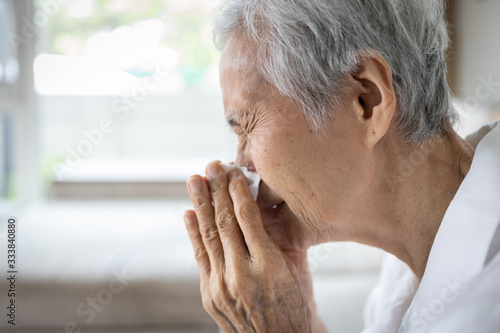 Sick asian senior woman hold paper tissue blowing running nose sneezing in handkerchief,seasonal flu,cold, ill elderly people suffer from influenza,infection symptoms of Covid-19,Coronavirus pandemic