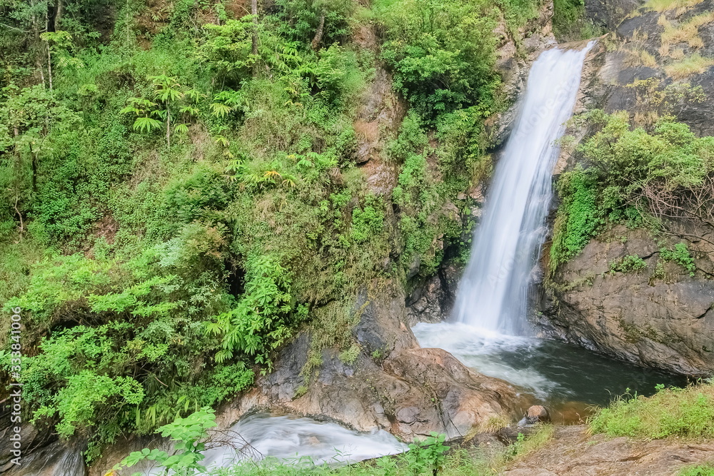 view of silky waterfall flowing on cliff rocks around with green forest background, Mae Pan Waterfall, Doi Inthanon National Park, Chiang Mai, northern of Thailand. view of silky waterfall flowing on cliff rocks around with green forest background, Mae Pan Waterfall, Doi Inthanon National Park, Chiang Mai, northern of Thailand.