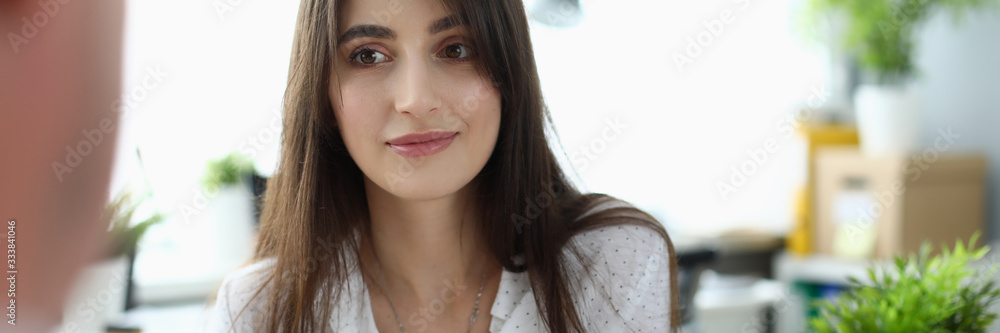 Portrait of cheerful businesslady talking with client. Pretty woman looking at man with gladness. Business and art design concept. Blurred background Portrait of cheerful businesslady talking with client. Pretty woman looking at man with gladness. Business and art design concept. Blurred background