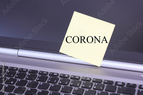 a piece of paper on a keyboard with the text "CORONA"