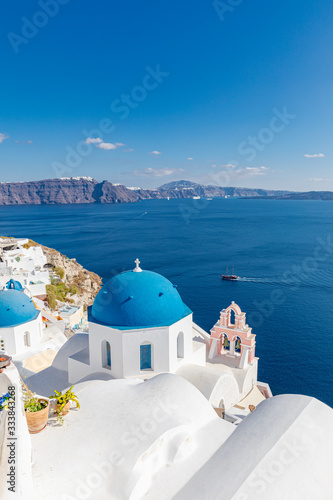 Beautiful Oia town on Santorini island  Greece. Traditional white architecture and greek orthodox churches with blue domes over the Caldera  Aegean sea. Scenic luxury travel background.