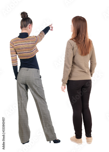 Back view of two pointing girl in sweater.